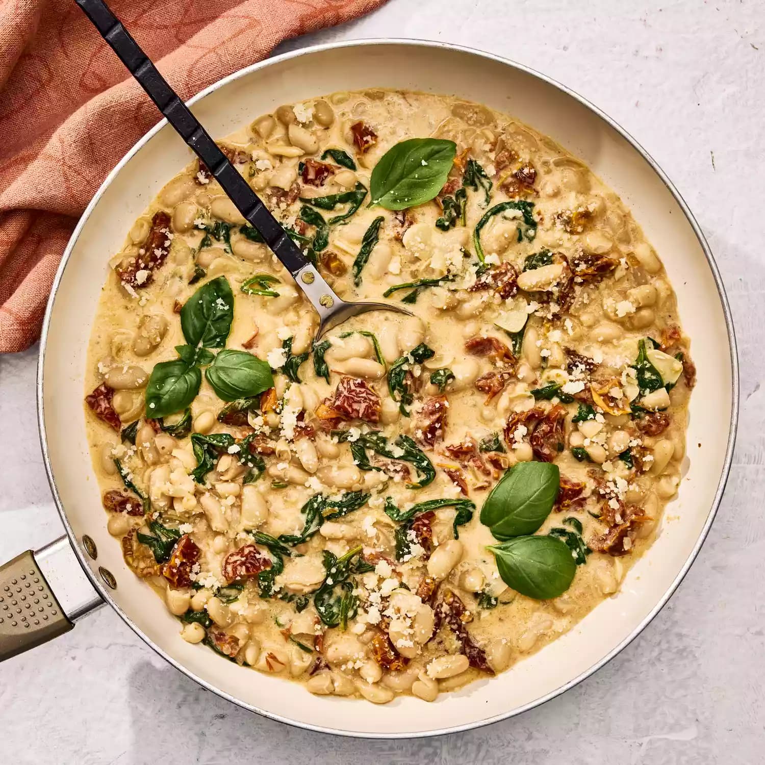 Alubias blancas con espinacas y tomate seco en sartén