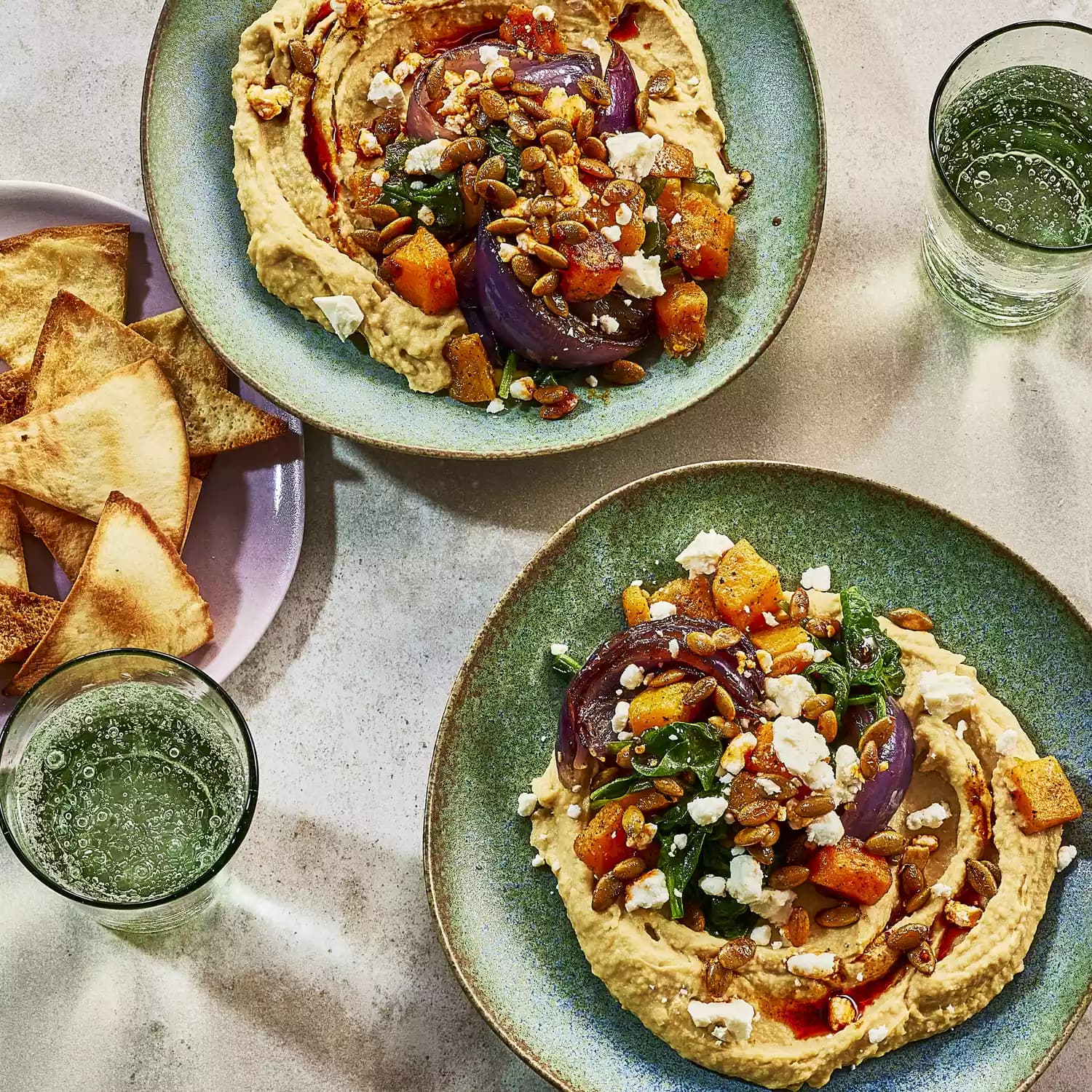 Bol de hummus con calabaza asada, espinacas y pepitas